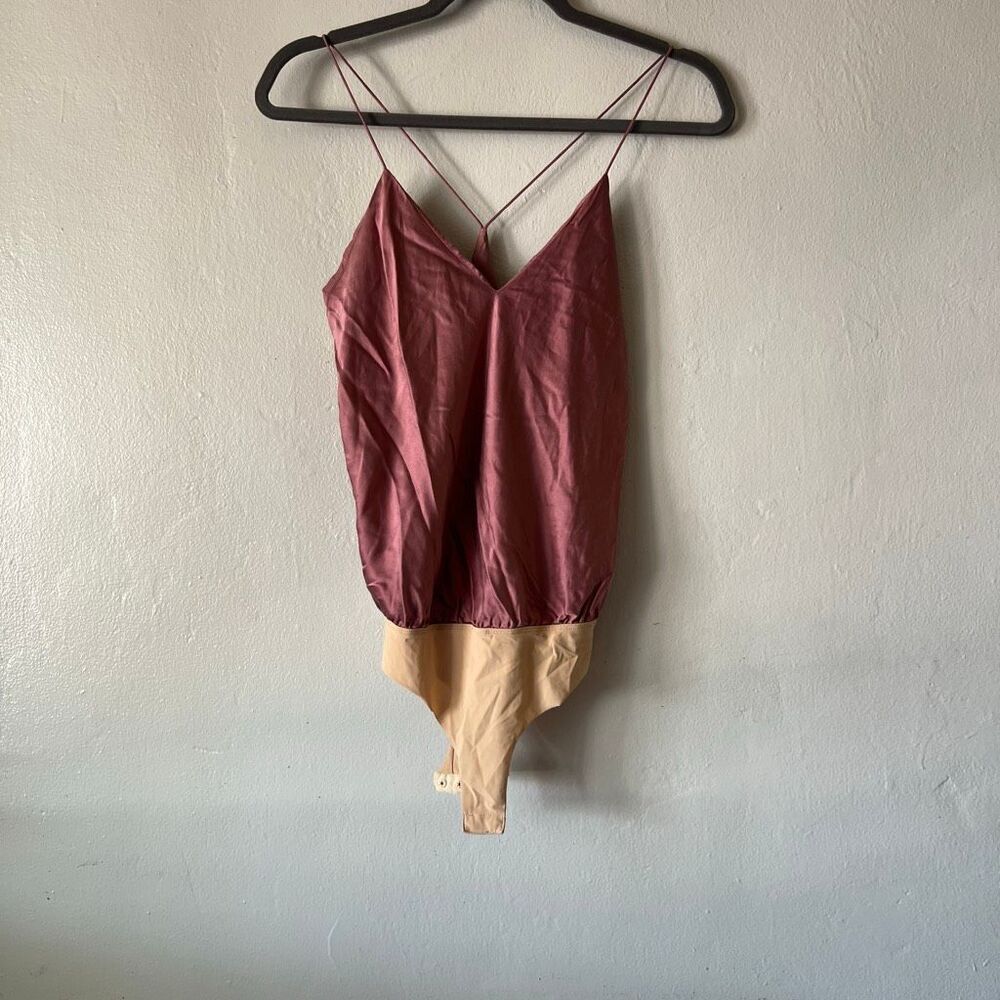 This burgundy silk V-neck bodysuit by Alix NYC features delicate cross-back stra